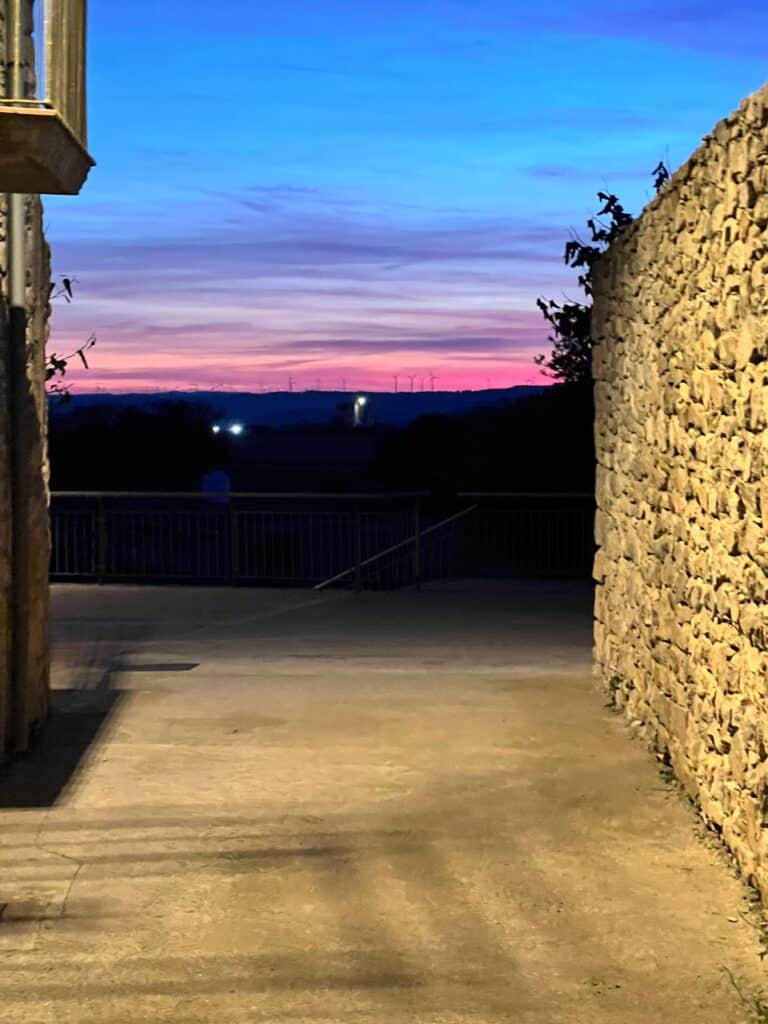 Evening sky with deep blue and pink sunset colors framed by Casa Pardal's stone walls, capturing the peaceful rhythm of rural coliving.
